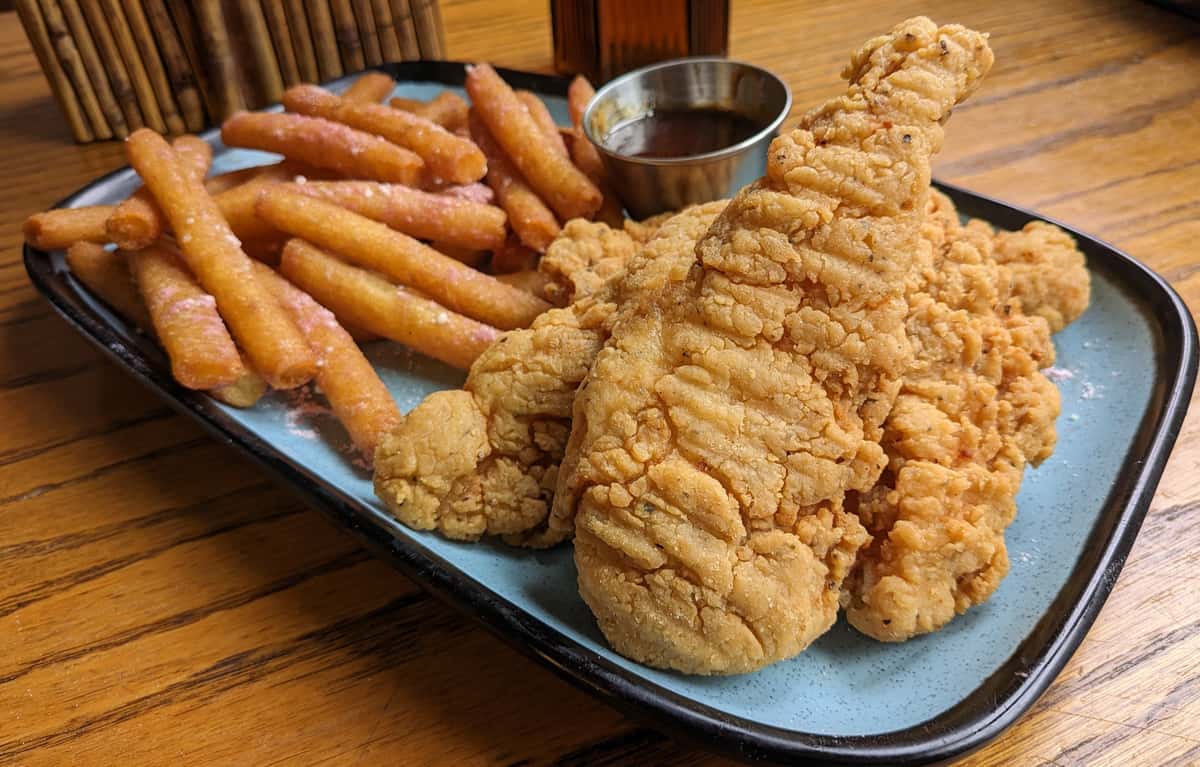 An amplified version of Chicken & Waffle! Funnel Cake Fries dusted with strawberry confection sugar and fried boneless chicken with a side of hot honey. A must try!