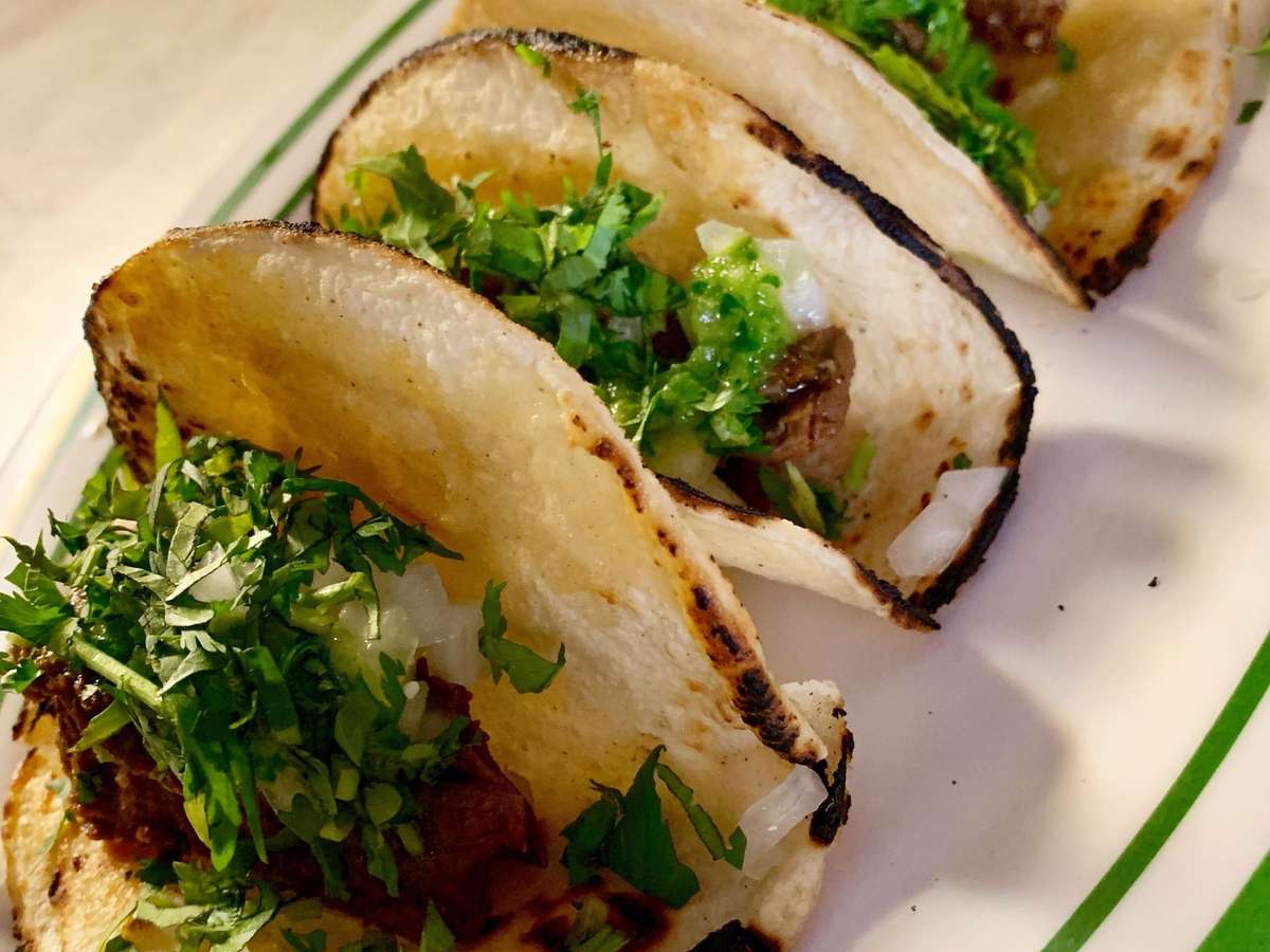 Steak street style tacos in corn tortilla shells on a plate