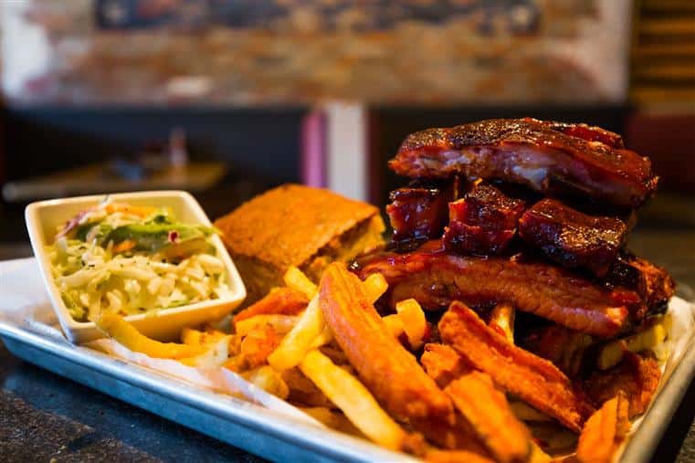 Plate of barbecue ribs with fries and cornbread