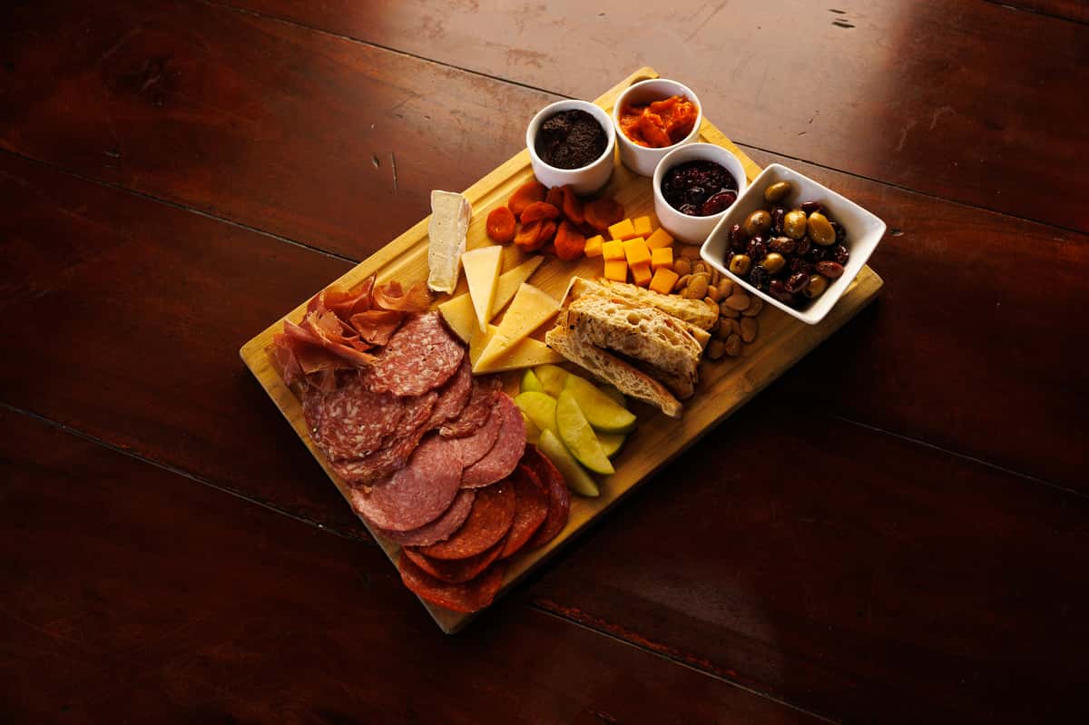 Charcuterie board with sliced meats, artisan cheeses, olives, pickled vegetables, and house-made accompaniments at EVO North Scottsdale.