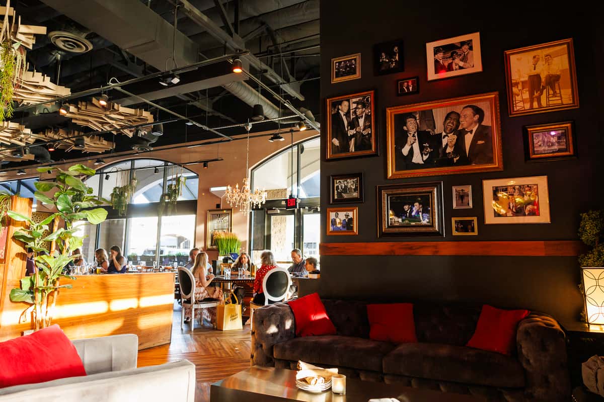 Comfortable lounge seating area with curated wall art, plush booths, and a modern cocktail bar vibe in North Scottsdale.