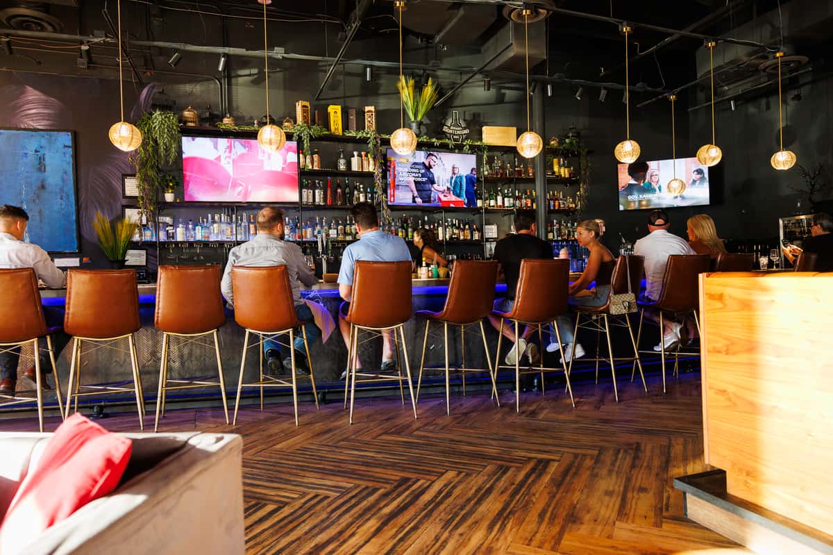 Modern sports lounge interior with bar seating, large-screen TVs, craft cocktails, and an energetic nightlife atmosphere in North Scottsdale.