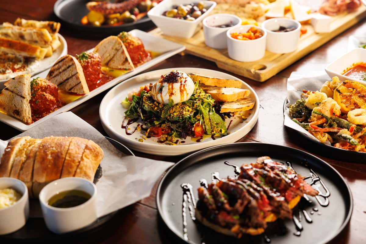 Chef-curated spread of shareable appetizers, entrees, and cocktails showcasing EVO Old Town Scottsdale's diverse menu.