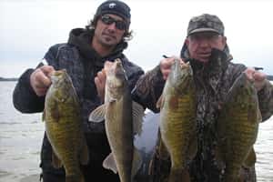 two men holding fish posing for a photo