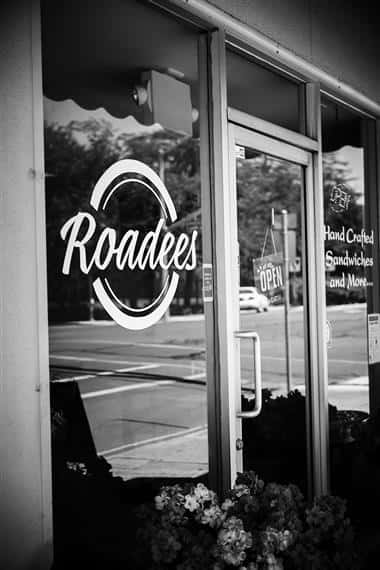 exterior view of roadees cafe window decal with open sign on door