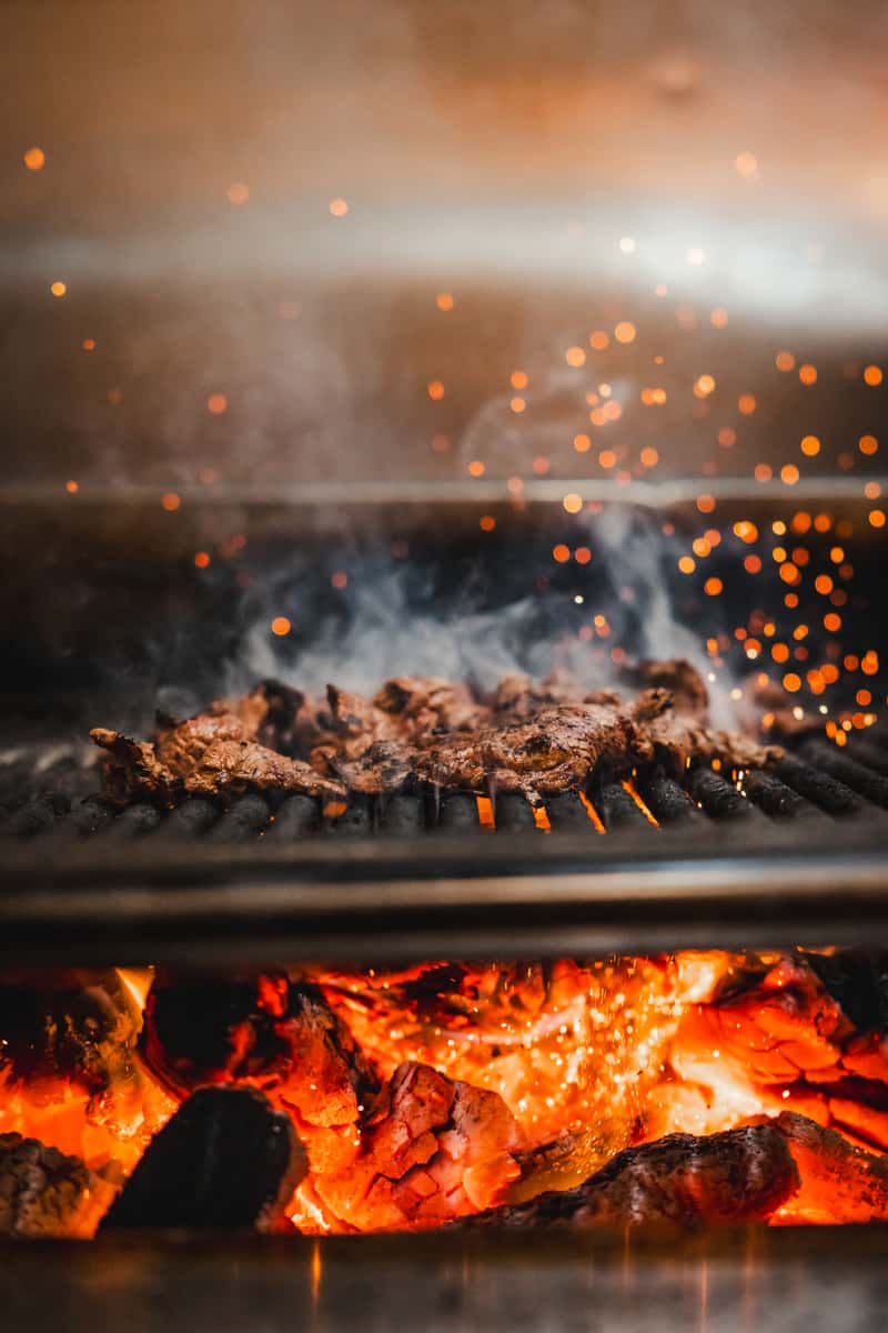 Steak cooking on an open flame grill