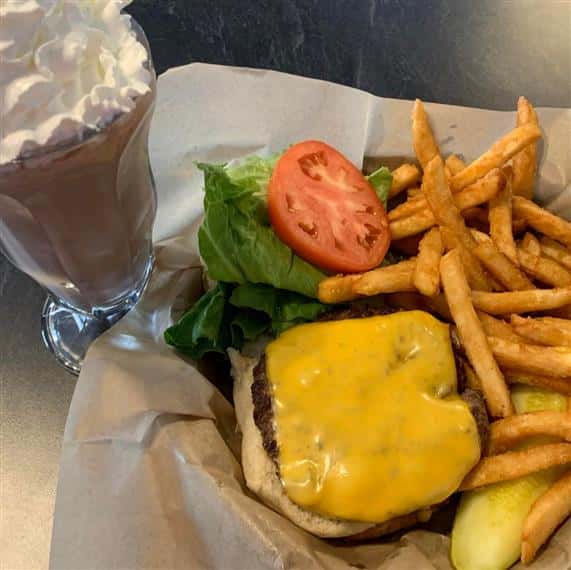 cheeseburger with fries, a pickle and a milkshake