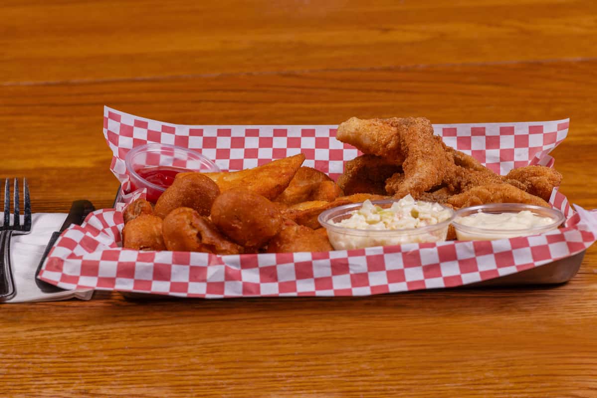 Crispy fried catfish basket with hush puppies and sides at Jake & Rip's in Grenada, Mississippi.