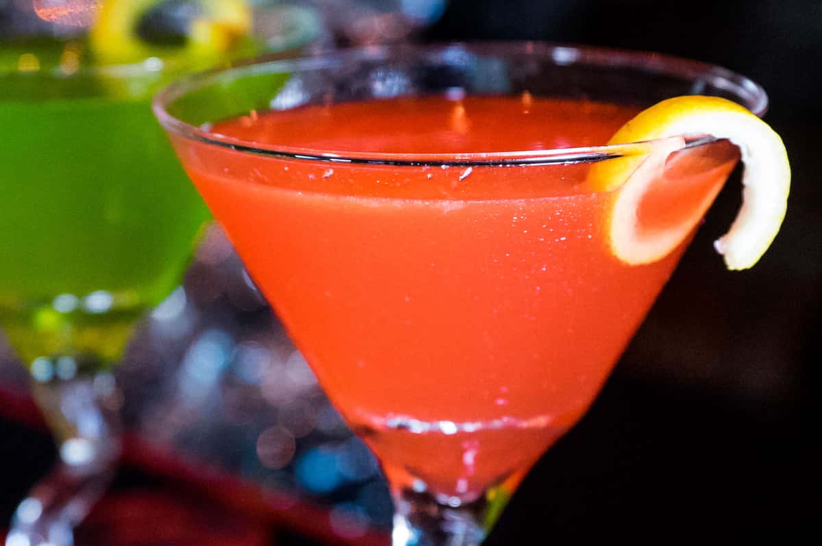 two martinis with lemon wedge garnish on a bar