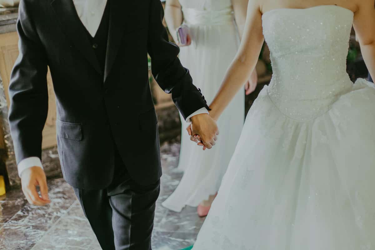 groom and bride holding hands