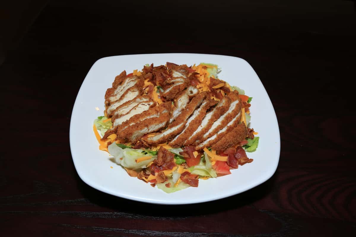 A mixed blend of romaine and iceberg lettuce topped with chicken tender strips, shredded cheddar, crumbled bacon, diced tomatoes & Ranch Dressing.