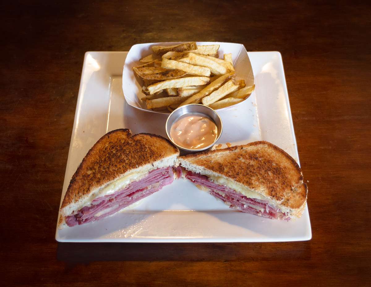 NY Style Reuben sandwich served with fries.
