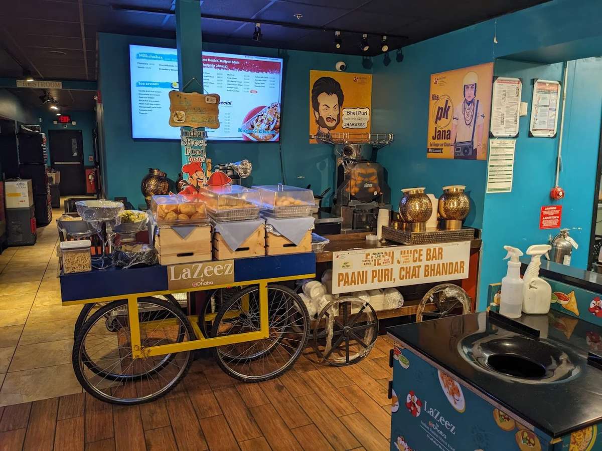 Indian street food–inspired restaurant interior with a traditional chaat cart display, pani puri setup, and decorative brass pots, creating an authentic market-style dining experience.