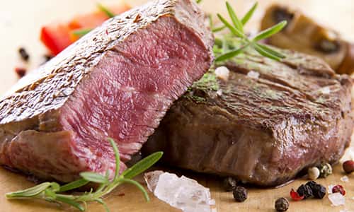 Thick cut steak medium rare with rosemary, peppercorns, salt