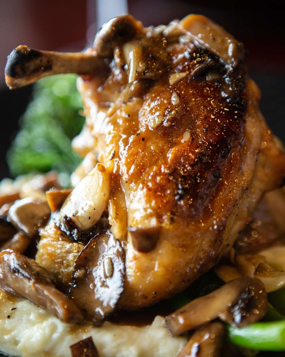 Pan-seared chicken breast topped with sautéed mushrooms over creamy mashed potatoes and wilted greens.