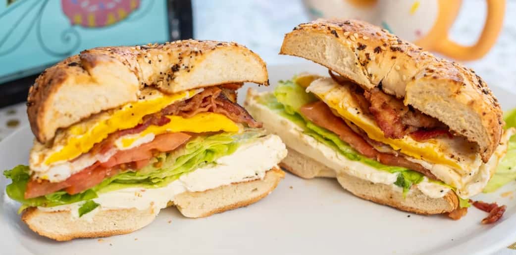 2 eggs over medium, bacon, lettuce, tomato, and vegetable cream cheese on a toasted everything bagel