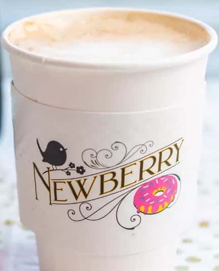 A latte in a new berry cup.