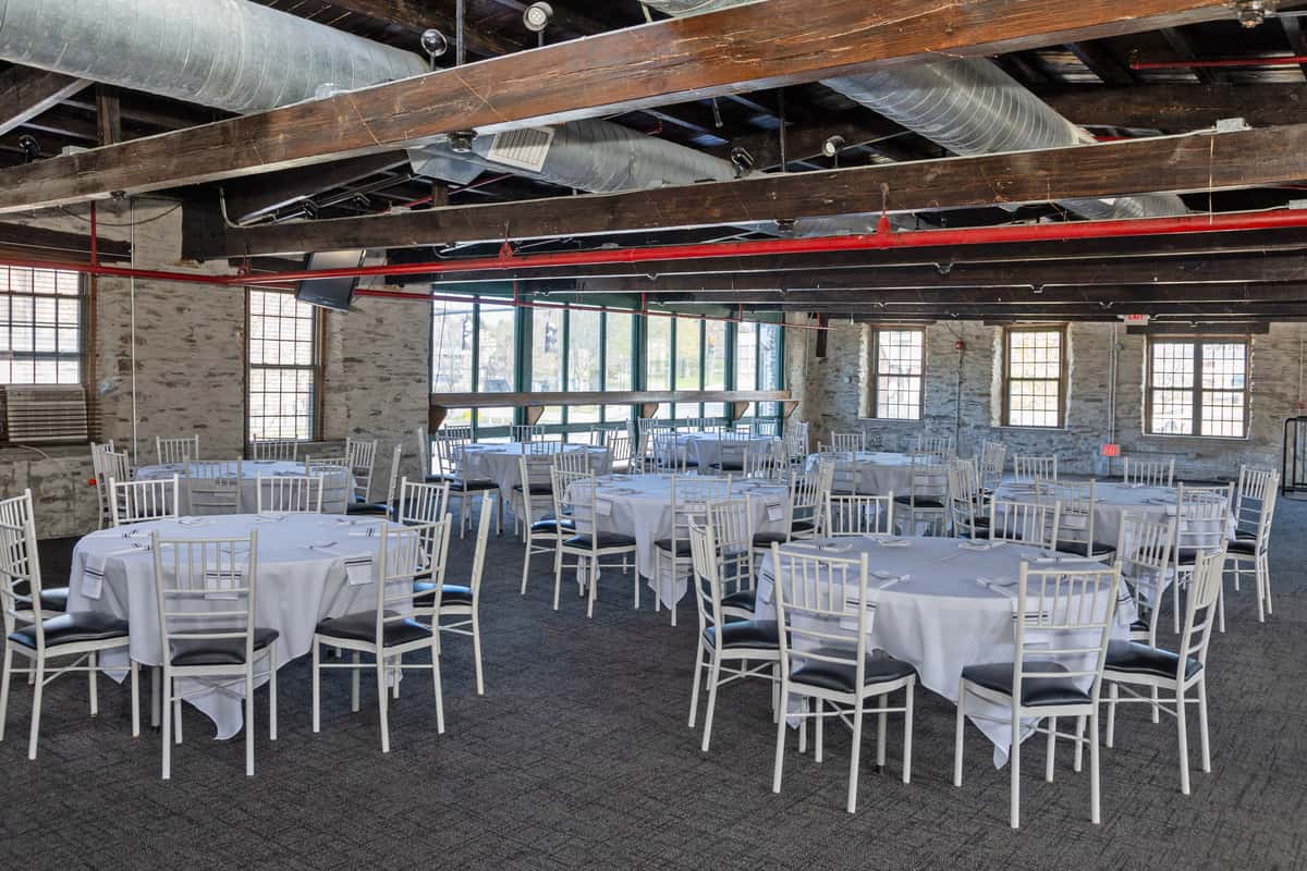 large banquet hall with white tables and chairs arranged for a formal event