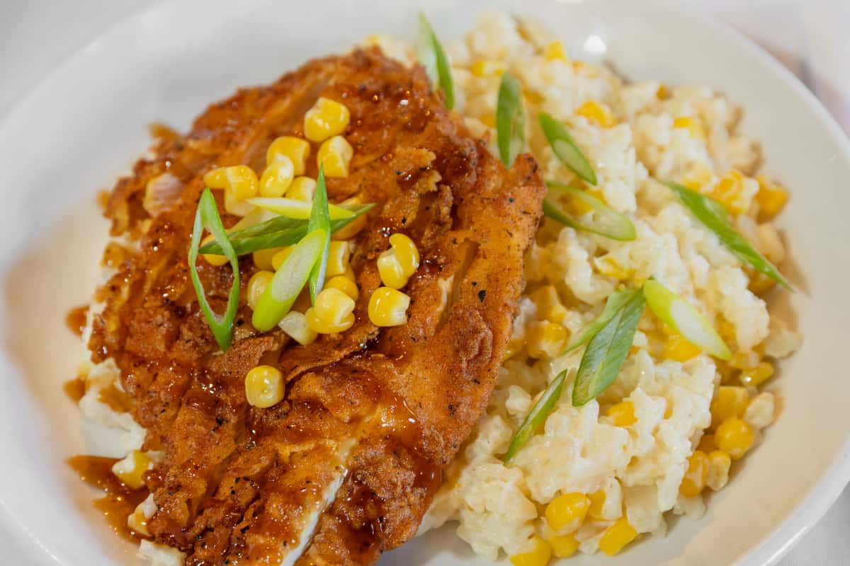 bourbon chicken bowl with creamy mashed potatoes, sweet corn, and green onion garnish