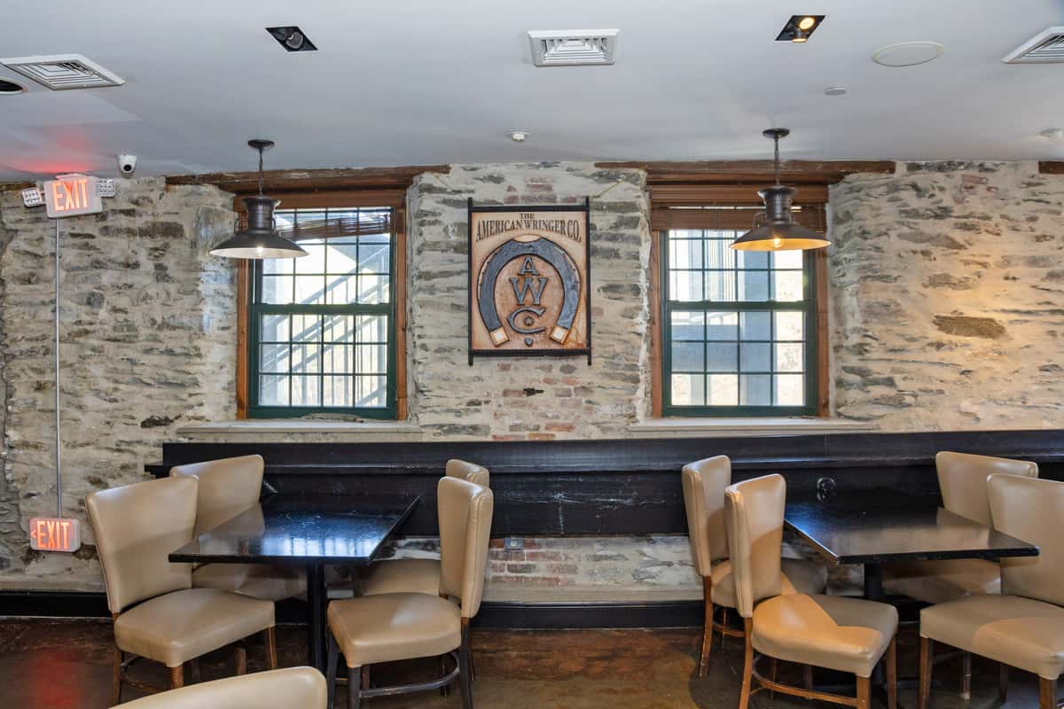 modern restaurant lounge with stone walls, booth seating, and upscale casual dining decor