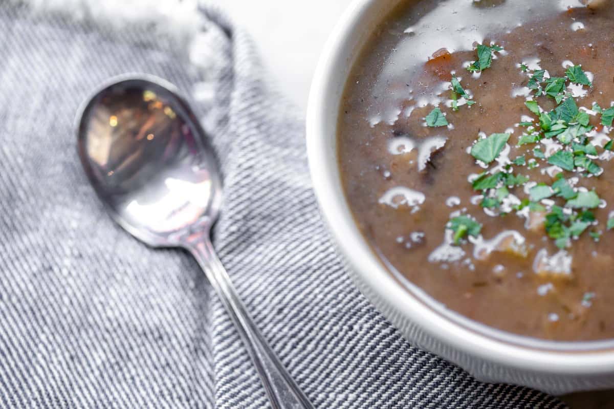 Mushroom barley soup with metal spoon
