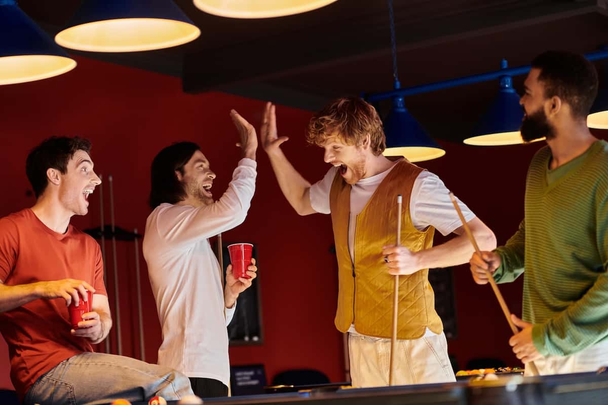 the perfect high five between two men playing billiards