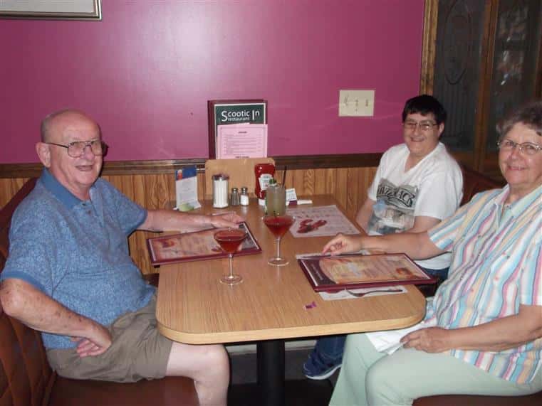 male and two females posing for a picture at a booth