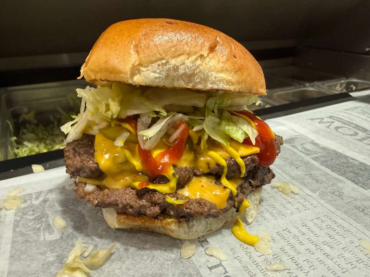 (2)1/4lb patties, (2)american cheese, ketchup, mustard, pickle, onion and lettuce on a toasted bun.