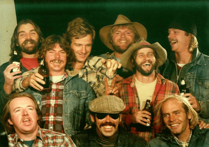 group of men holding beers smiling for picture