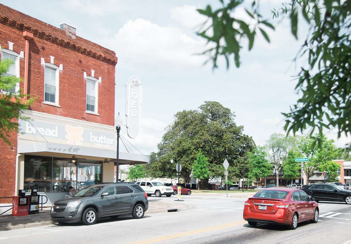 Bread & Butter Bakery storefront on a charming downtown corner, featuring outdoor seating and a historic brick building facade.