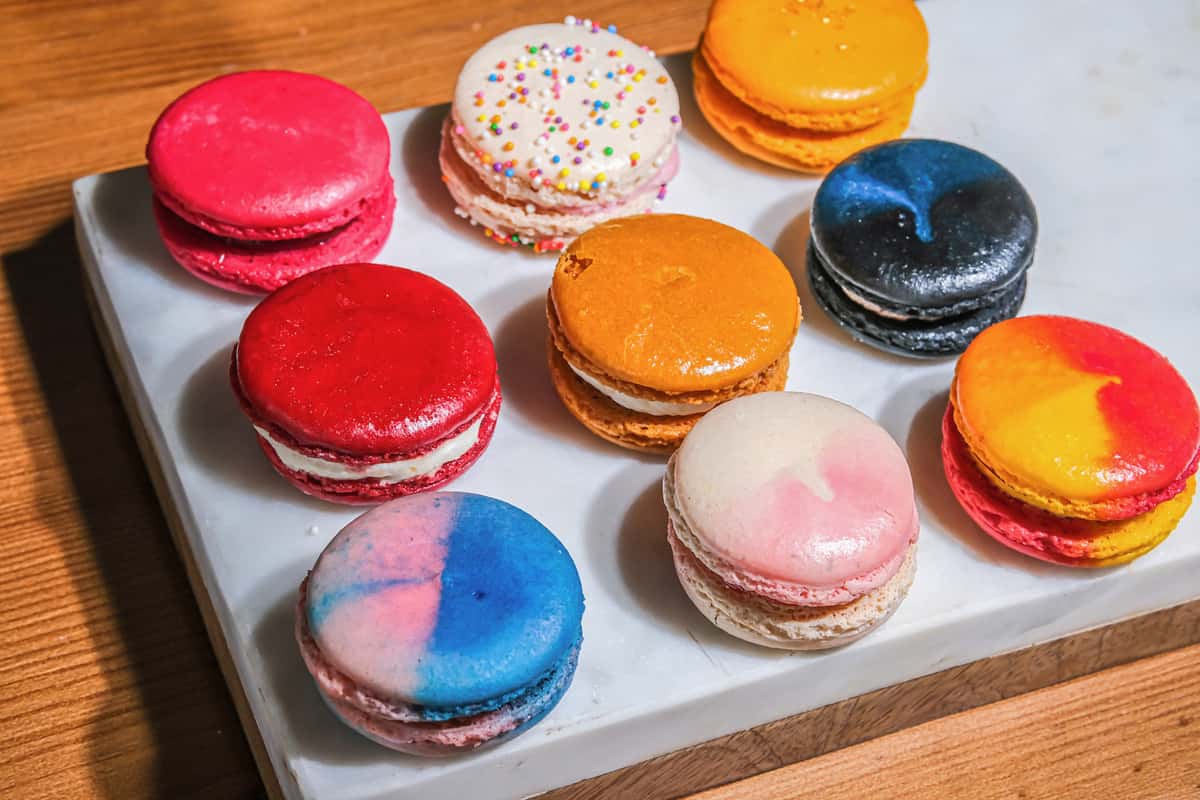 Assorted handcrafted French macarons in vibrant colors at Bread & Butter Bakery and Cafe, featuring a variety of gourmet flavors and elegant presentation.