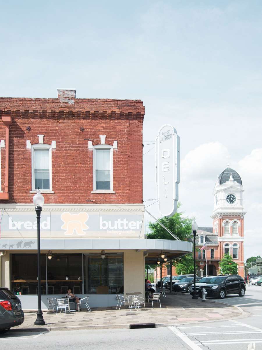 Bread & Butter Bakery and Cafe storefront on a charming downtown corner with outdoor patio seating and a historic courthouse cloc