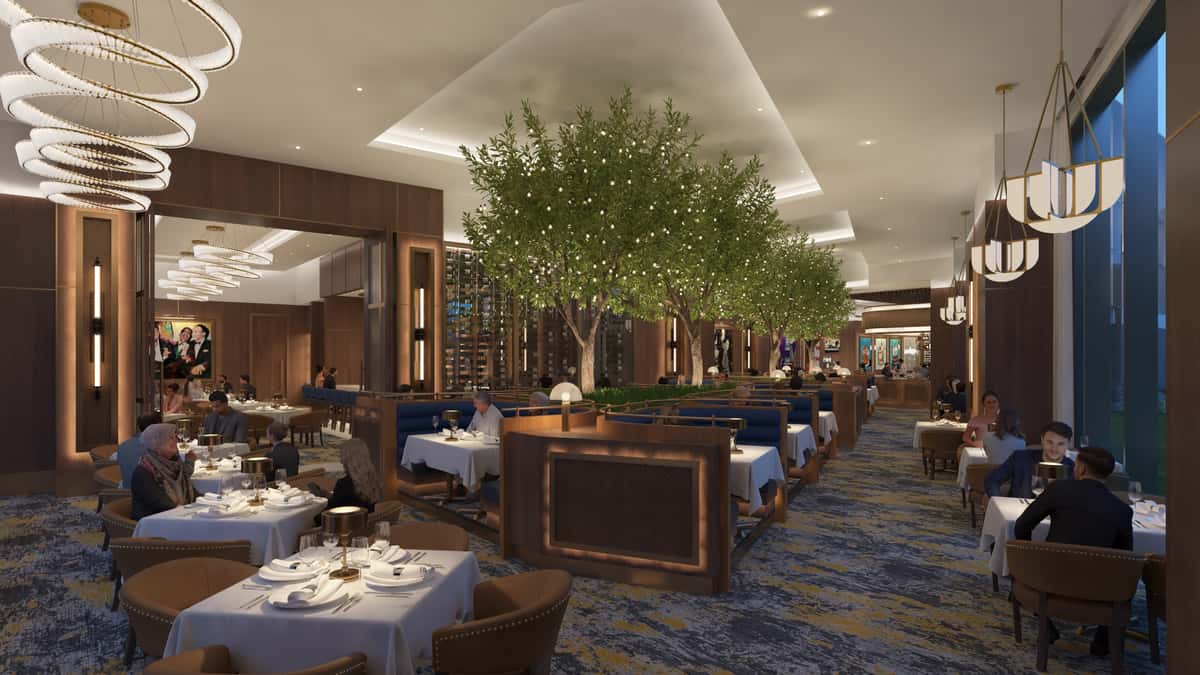 Elegant fine dining restaurant interior with lush greenery, white tablecloth seating, and warm contemporary décor.