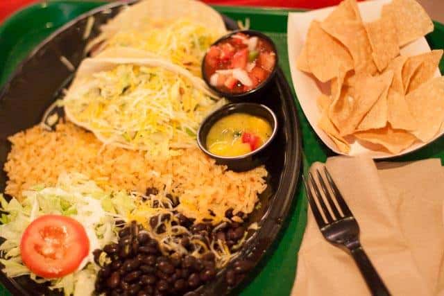 Taco plate served with rice and dips on the side with tortilla chips