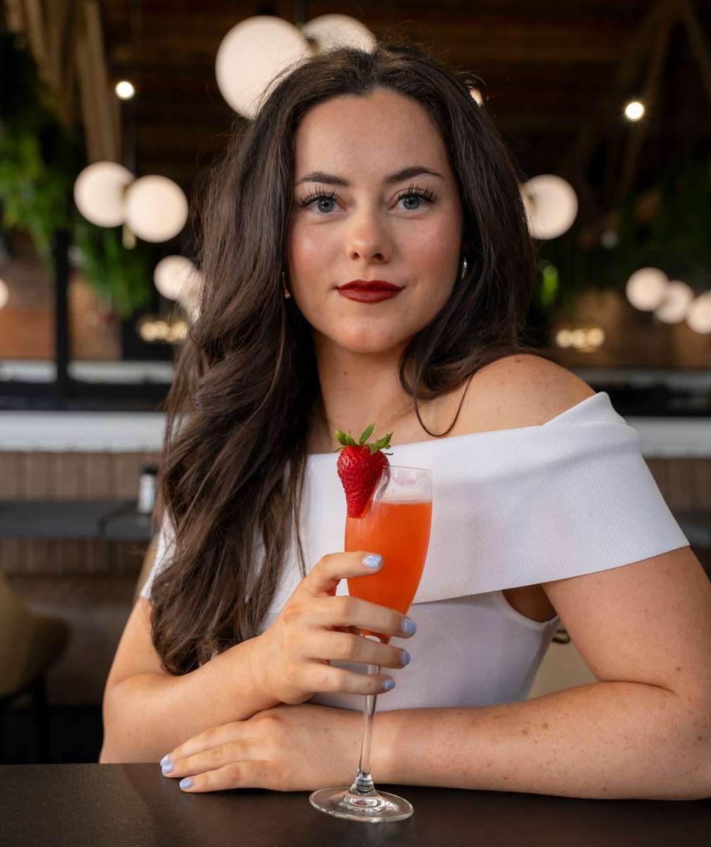 model holding strawberry cocktail