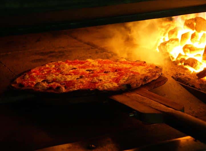 Pizza going in coal fired oven