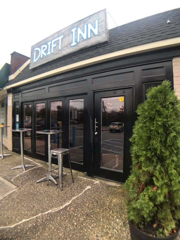Exterior of Drift Inn with high tables and chairs set up
