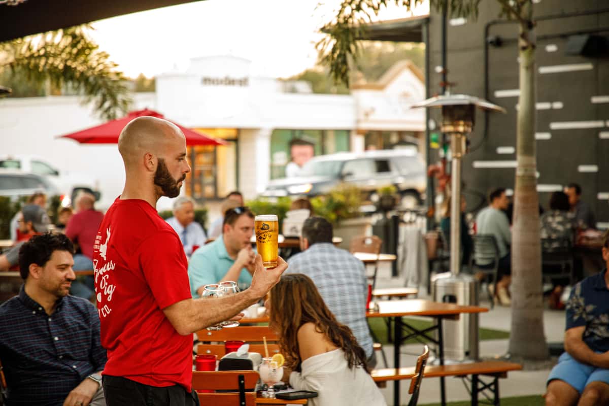 Photo of server serving a beer to patrons