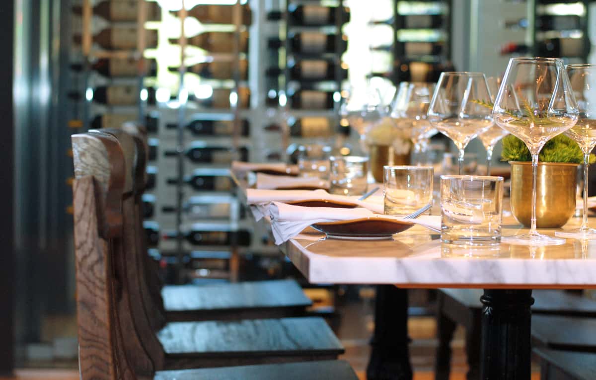 marble table top set with place settings and wine glasses