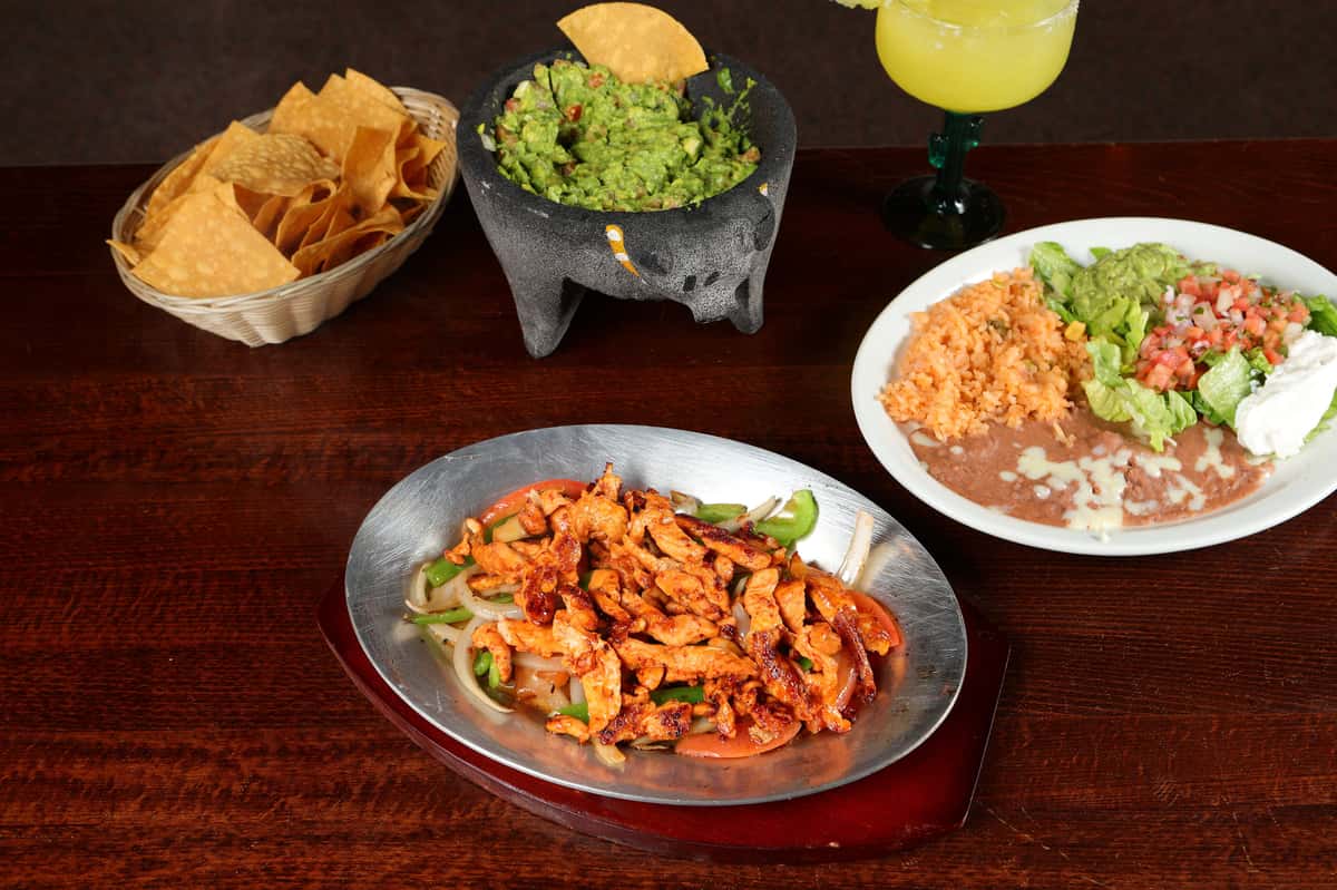 Silver plate on top of a wooden table with mexican food
