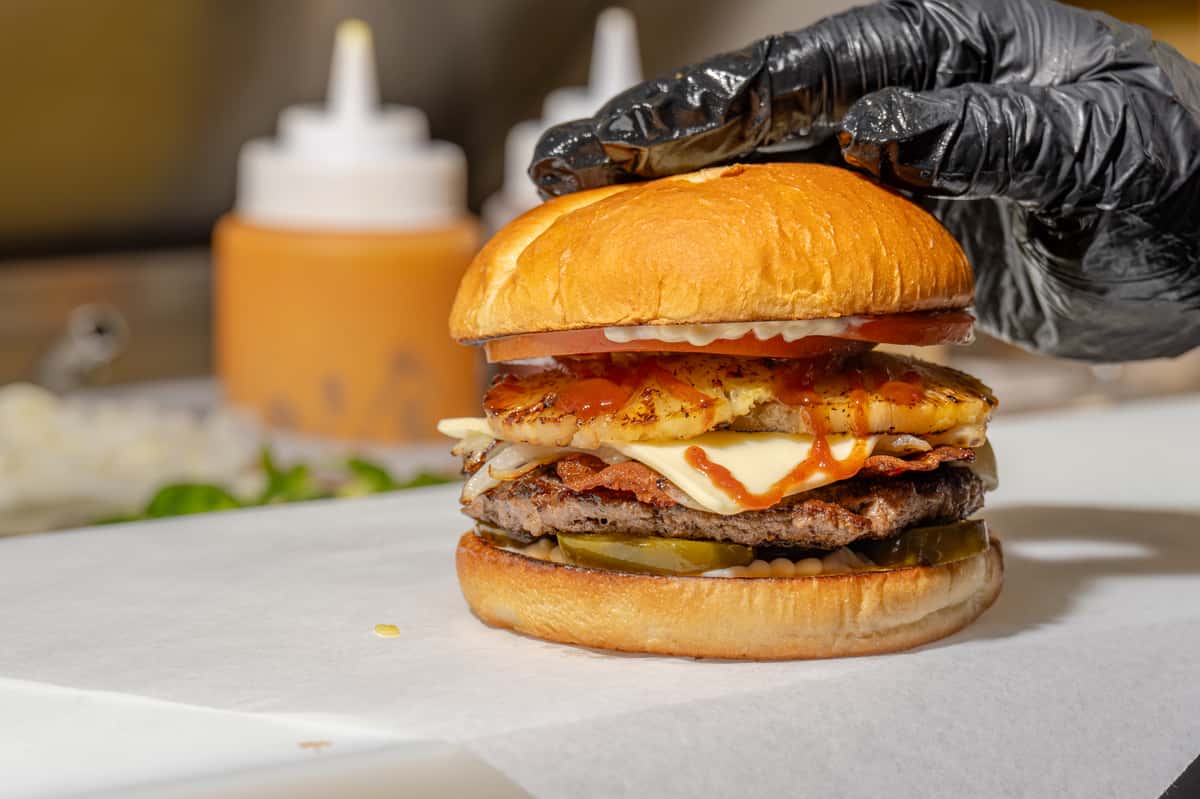 Single Angus Beef Patty, Brioche Bun, Bacon, Swiss Cheese, Mayo, BBQ Sauce, Tomatoes, Grilled Onions, Pickled Jalapenos, 2 Slices of Pineapple
