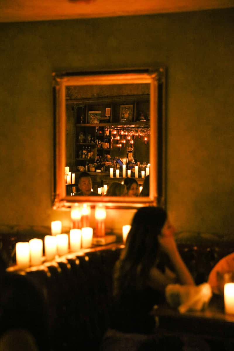 Candlelit Habana dining room reflected in a vintage mirror