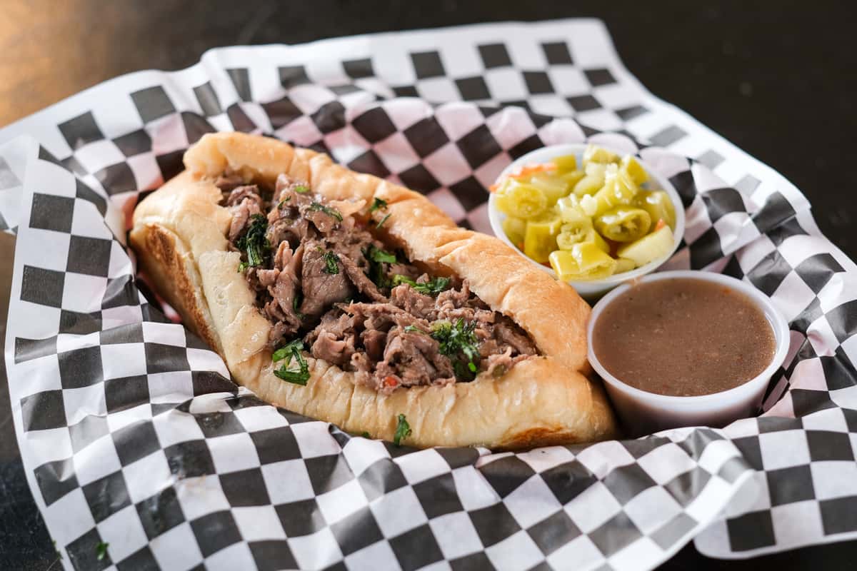 A true Windy City classic! Slow-roasted, thinly sliced roast beef piled high on a fresh, toasted roll, dripping with rich, savory au jus. Topped with spicy giardiniera for an authentic Chicago kick. Served with a side of fries.