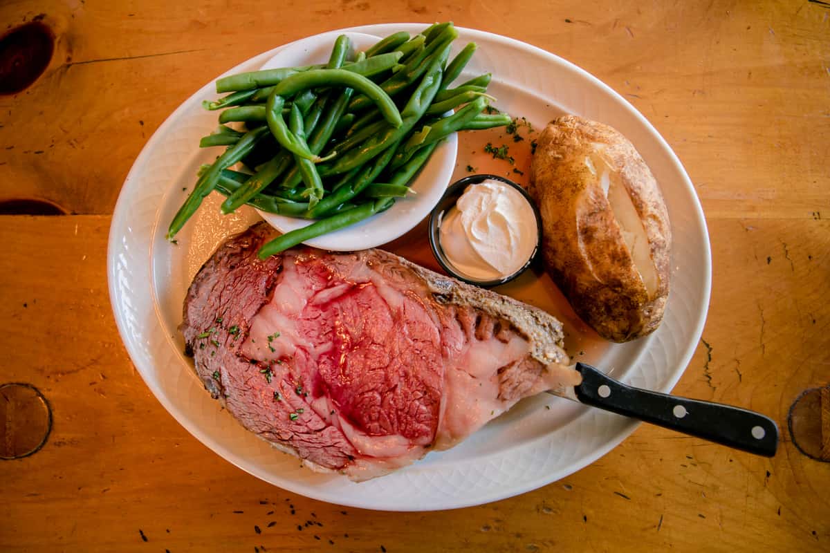 Roast beef slices served with green beans and classic sides.