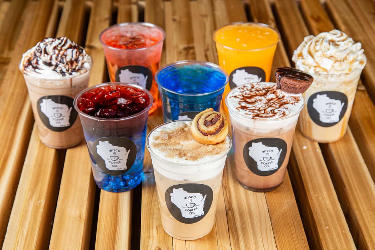 Colorful iced drinks and specialty lattes lineup with whipped cream and toppings at Wisco Coffee Company