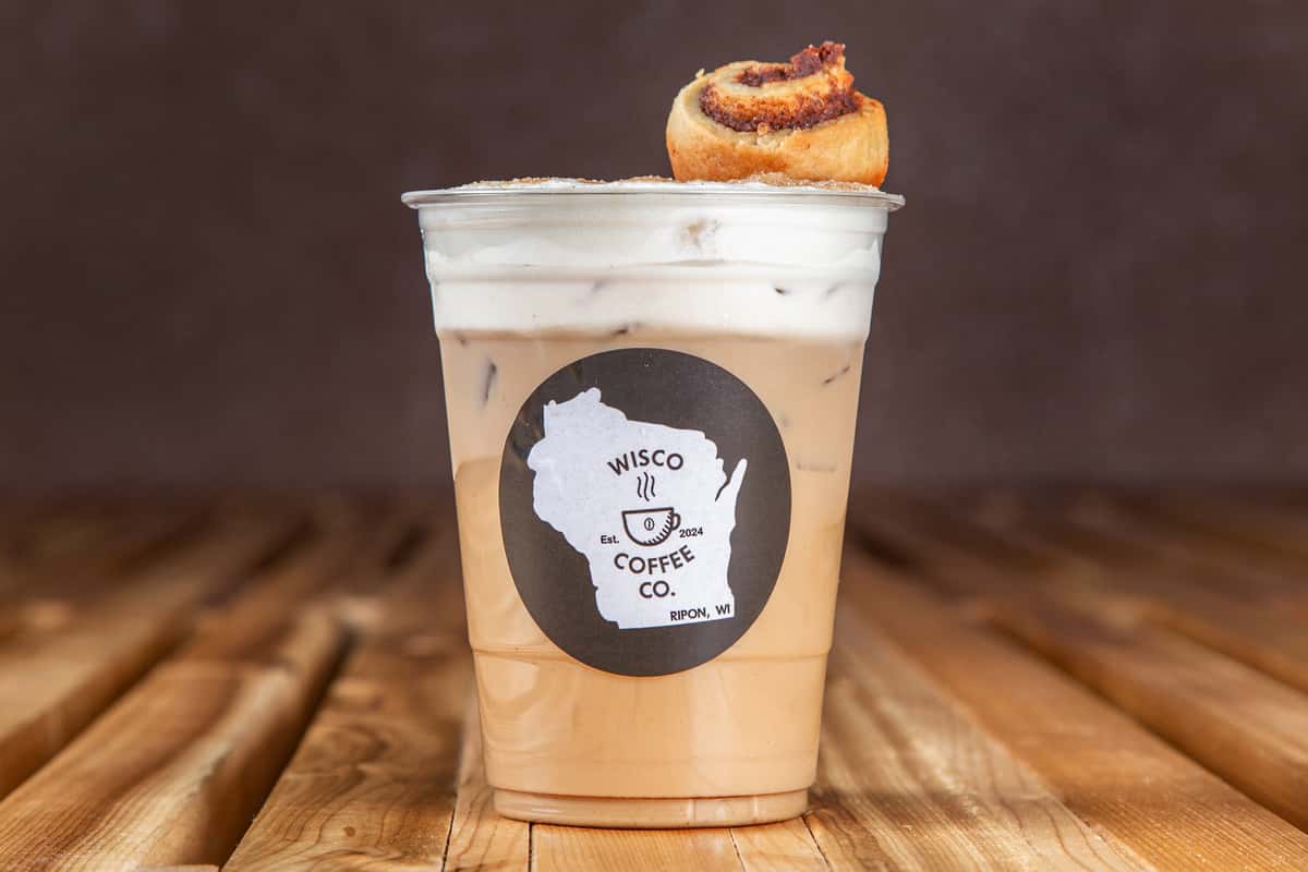 Iced cinnamon latte with whipped cream and cinnamon roll topping at Wisco Coffee Company