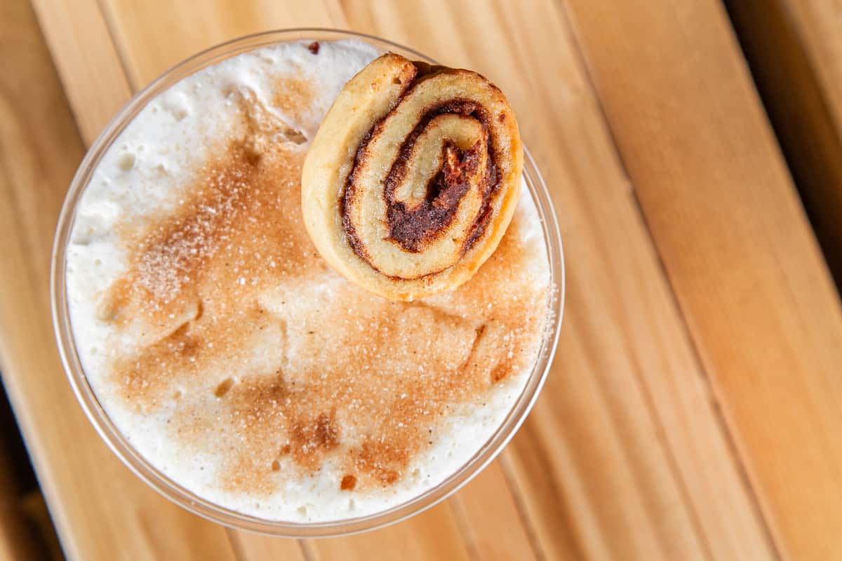 Iced cinnamon latte with whipped cream and cinnamon roll topping at Wisco Coffee Company