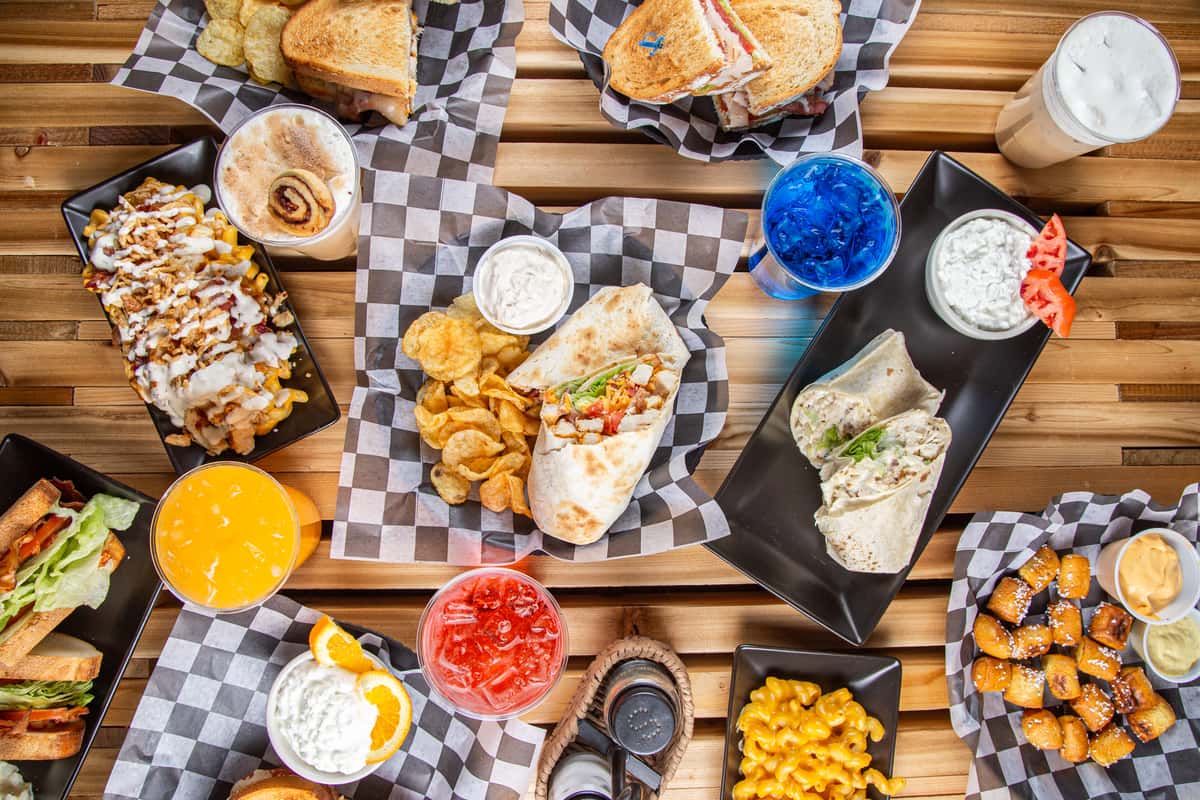 Top-down view of loaded fries, waffles, sandwiches, and iced drinks at Wisco Coffee Company