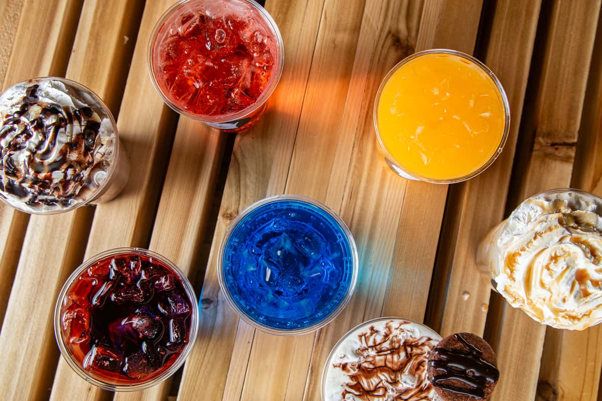 Colorful iced drinks and specialty lattes lineup with whipped cream and toppings at Wisco Coffee Company