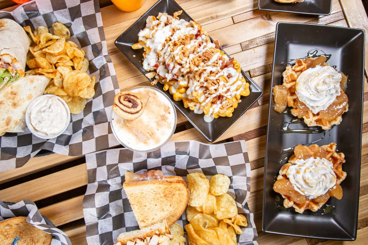 Cafe table filled with wraps, chips, iced drinks, and loaded fries at Wisco Coffee Company